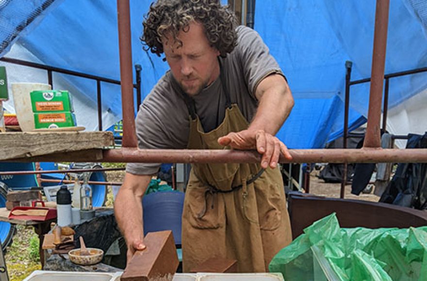 Sam Hallett building his clay bottle sculpture building for his hideout retreat 2022 project