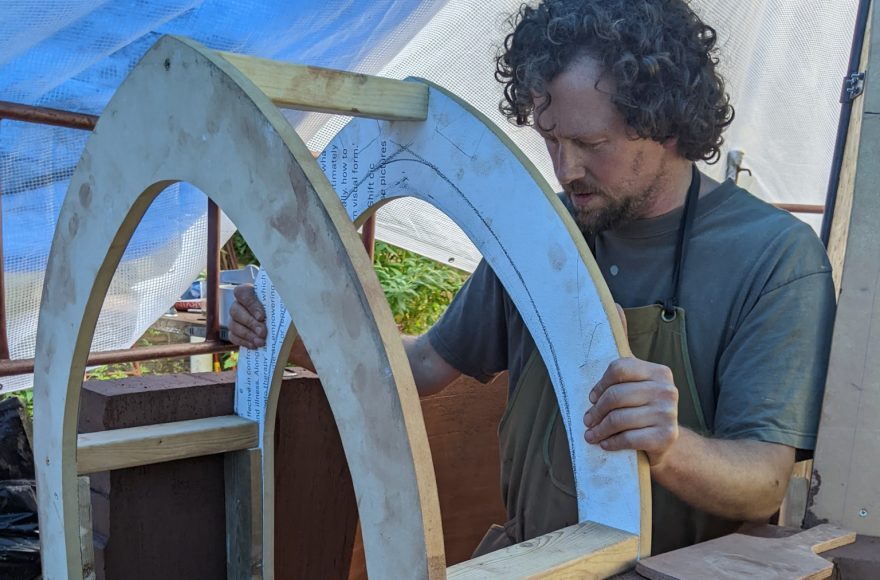 Sam Hallett building the doorframe for his clay bottle sculpture building for his hideout retreat 2022 project