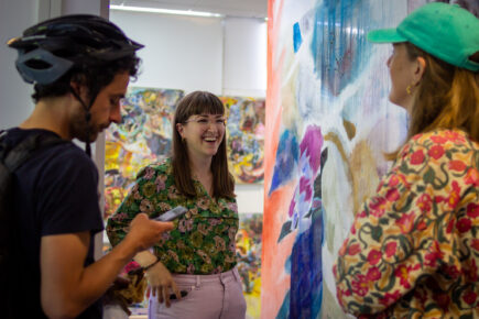 Artist Ellie Shipman talking in studio surrounded by artwork